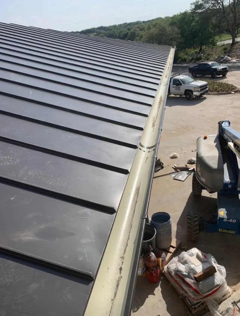 Standing seam panel and gutter detail on a metal roofing jobsite in Payson